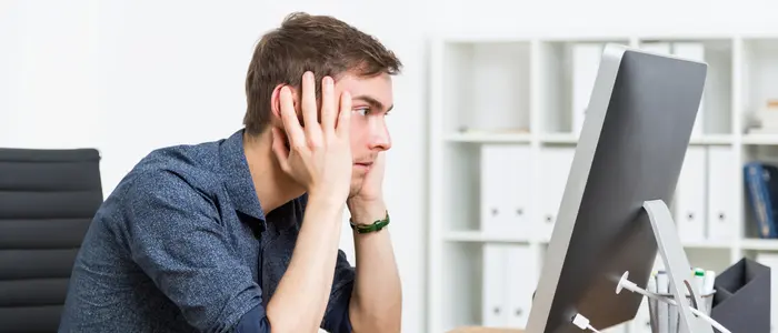 Empleado con baja productividad frente a un computador lento en oficina